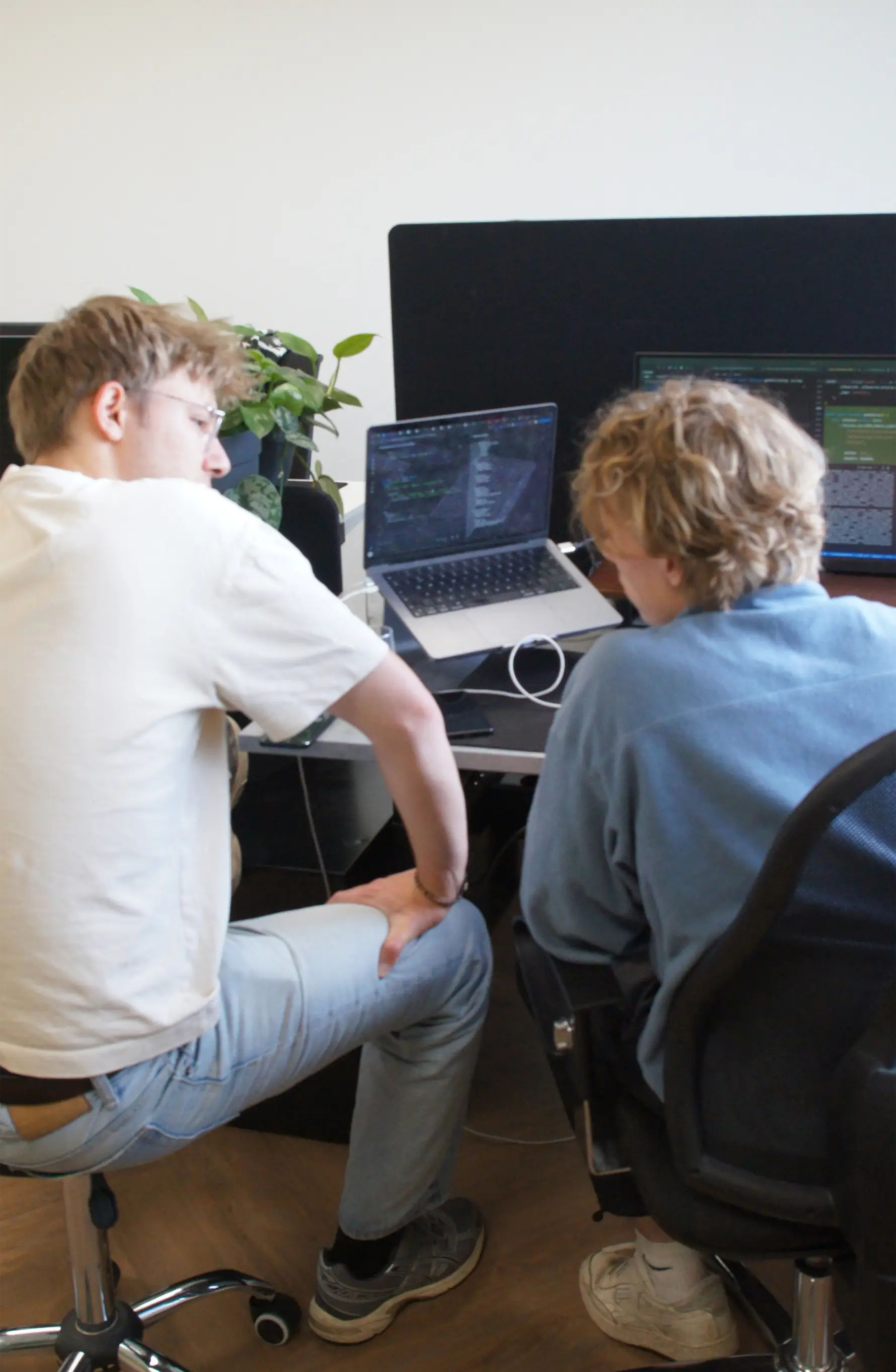 Twee teamleden van Tinzo werken samen achter een laptop